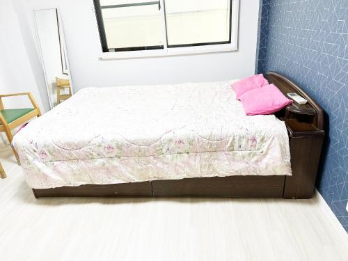 a bedroom with a bed with pink pillows on it at 花乃郷 本郷 in Tokyo
