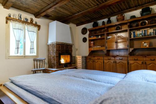 a bedroom with a large bed and a fireplace at Fantázia Kulcsosház in Ciumani