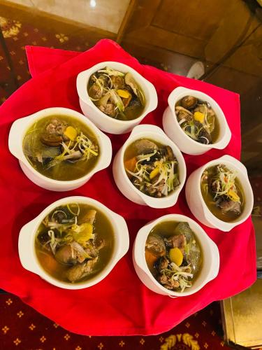 a group of bowls of food on a red table at Muong Thanh Luxury Nhat Le Hotel in Dong Hoi