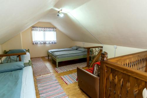 a attic room with two beds and a staircase at Fantázia Kulcsosház in Ciumani