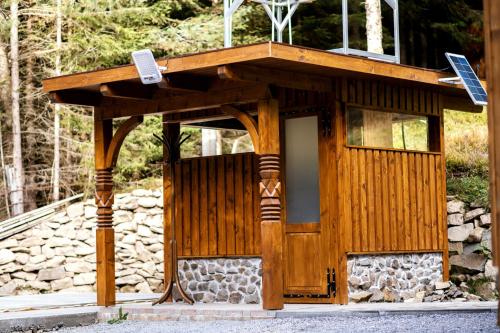 a wooden building with a door and a solar panel on it at Fantázia Kulcsosház in Ciumani