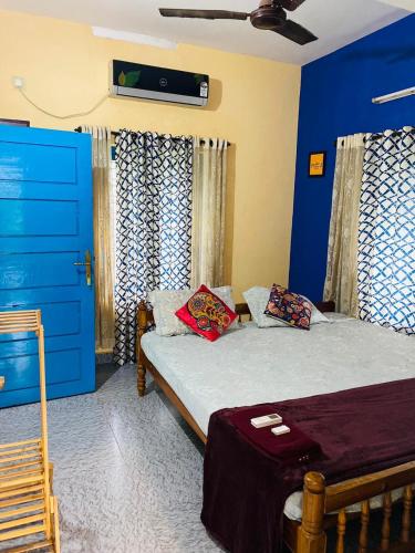 a bedroom with two beds and a blue door at Varkala Vibe in Varkala