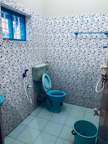 a bathroom with a blue toilet and two buckets at Varkala Vibe in Varkala