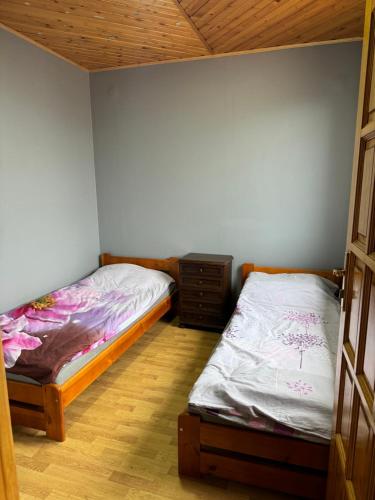 two twin beds in a bedroom with a wooden floor at Agroturystyka Działoszyce in Działoszyce