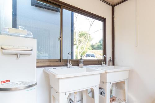 a bathroom with two sinks and a window at Glanchette岡山∼グランピング＆オートキャンプ∼ 