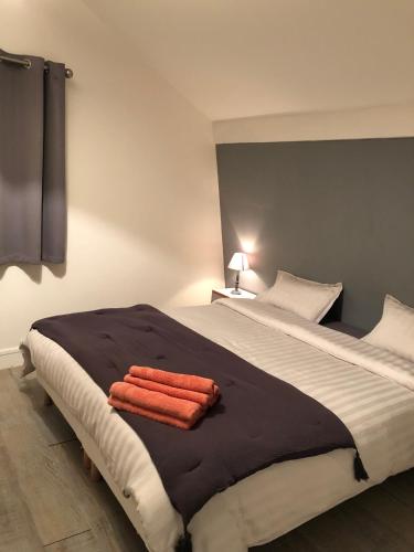 une chambre avec un grand lit avec deux serviettes dessus dans l'établissement à 30 m du coeur de la rue des Bains, à Trouville-sur-Mer