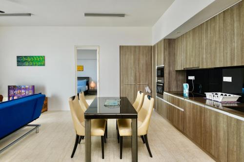 a dining room with a table and chairs at By The Sea Beach Front Apartment in Batu Ferringhi
