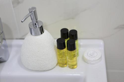 a bathroom sink with two bottles of soap and a toothbrush at Luxor Rabath in Akhaltsikhe