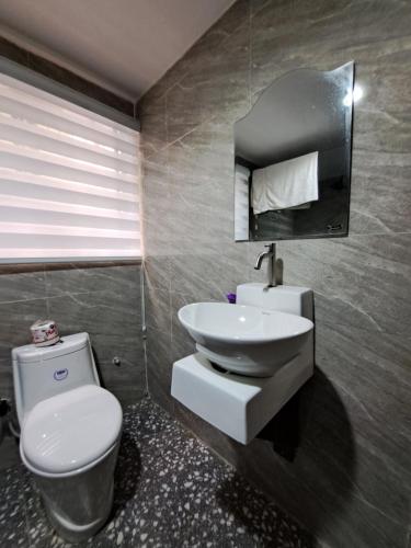 a bathroom with a toilet and a sink at Igbalode Luxury Apartment in Ibadan