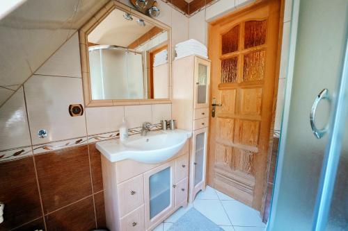 a bathroom with a sink and a mirror at Góralski Domek Polaniorka in Biały Dunajec