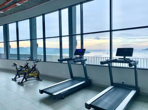 a gym with two exercise bikes in a room with windows at Botiza Suites at Jesselton Quay in Kota Kinabalu