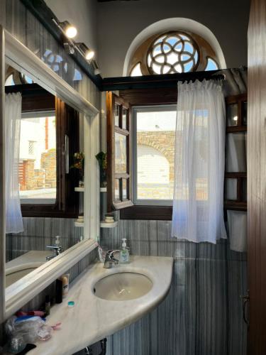 a bathroom with a sink and a window at Planitis Lighthouse View in Pánormos