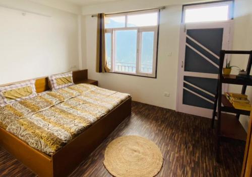 a bedroom with a bed and a large window at The Royal Orchard Homestay by StayApart in Nārkanda