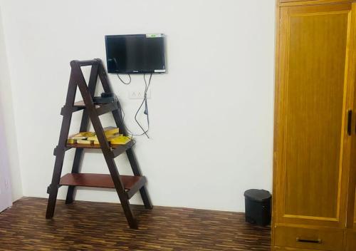 a wooden ladder with a television on a wall at The Royal Orchard Homestay by StayApart in Nārkanda