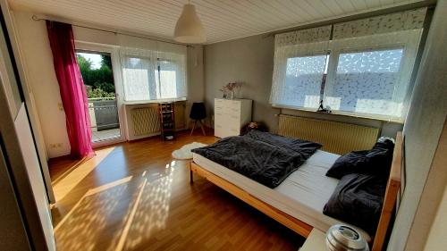 1 dormitorio con 1 cama y 2 ventanas en Zweite Heimat Bamberg, en Stegaurach