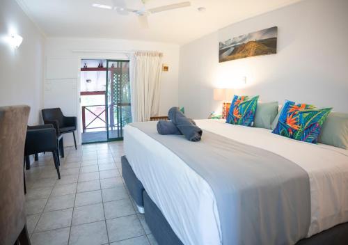 1 dormitorio con 1 cama grande, mesa y sillas en Kimberley Croc Motel, en Kununurra