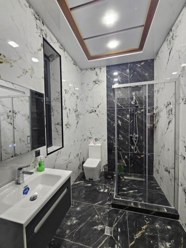 a bathroom with a sink and a glass shower at Dacha Akua Relax in Chorwoq