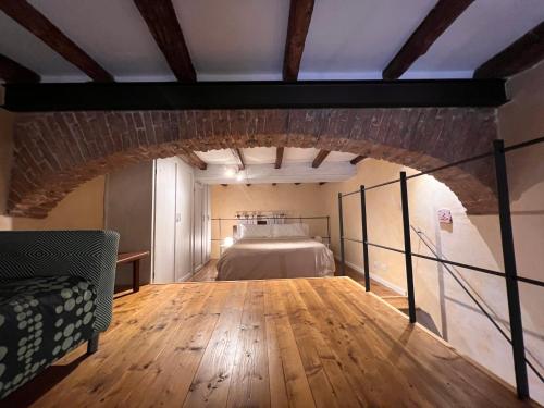 1 dormitorio con 1 cama en una habitación con suelo de madera en Without Name Apartment, en Bolonia