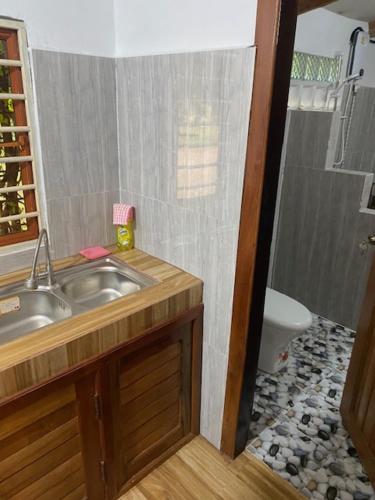 a bathroom with a sink and a shower with a toilet at Kraoul Seh - Horse Riding Cambodia in Kampot