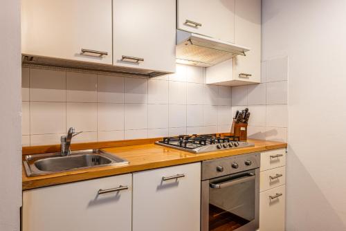 a kitchen with a sink and a stove top oven at Duomo-Porta Romana "Casa del Pittore" in Milan