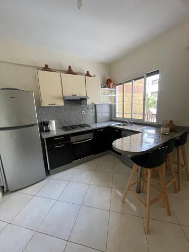 a kitchen with a refrigerator and a table in it at Petit appartement 68m2 quartier Bourgogne in Casablanca