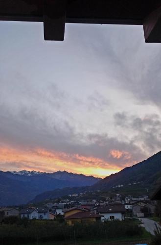 a view from a window of a city at sunset at ValtellinaHome in Villa di Tirano