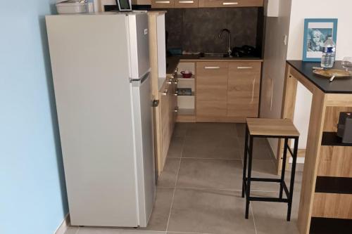 a kitchen with a white refrigerator and a table at Nouveau Loft T2, connecté internet fibre et wifi in Saint-Quentin