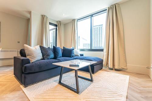 a living room with a blue couch and a table at 1 Bed Apt - Balcony - City View - Great Location in Liverpool