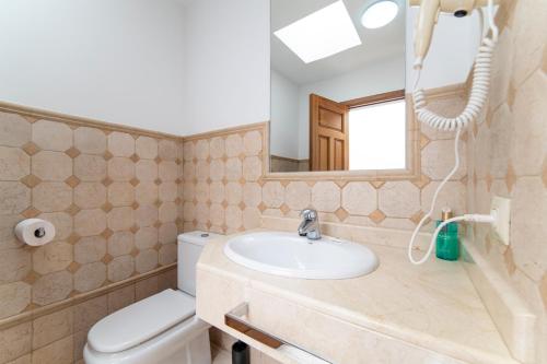 a bathroom with a sink and a toilet and a mirror at Jasmin in Puerto Calero