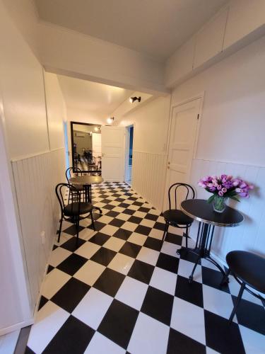 una stanza con pavimento a scacchi e tavoli e sedie di Hietaman Vierastalo Marilyn ad Äänekoski