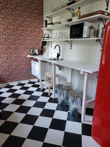una cucina con pavimento a scacchi in bianco e nero di Hietaman Vierastalo Marilyn ad Äänekoski