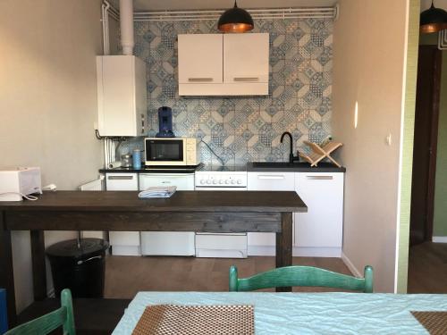 - une cuisine avec une table en bois et un four micro-ondes dans l'établissement Amazone - Appart Au Top !, à Metz