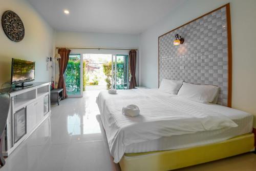 een slaapkamer met een groot bed en een televisie bij Happy Garden Resort Betong in Betong