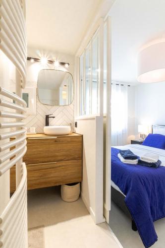 une chambre avec un lit, un lavabo et un miroir dans l'établissement L'Oasis 4 étoiles - Triangle d'Or, à 100m du Lac, Parking gratuit, à Annecy