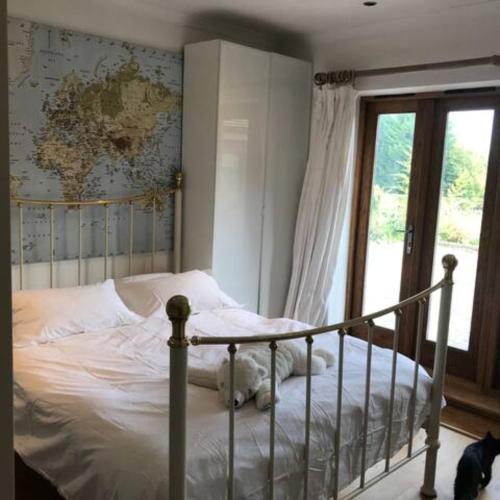 a white cat laying on a bed in a bedroom at Prestwick Oak - Sleeps 10-14 - Group Accommodation for Family or Friends in Haslemere