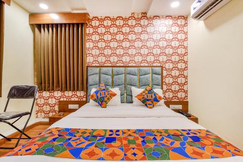 a bedroom with a bed with a patterned wall at FabExpress Md in Vadodara