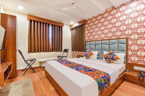 a bedroom with a large white bed in a room at FabExpress Md in Vadodara