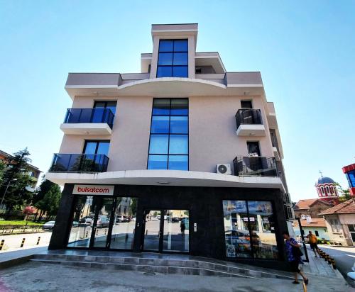 a building with people walking in front of it at Xelibri Apartment in Gorna Oryakhovitsa
