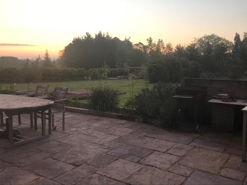 a patio with a table and chairs and a piano at Prestwick Oak - Sleeps 10-14 - Group Accommodation for Family or Friends in Haslemere