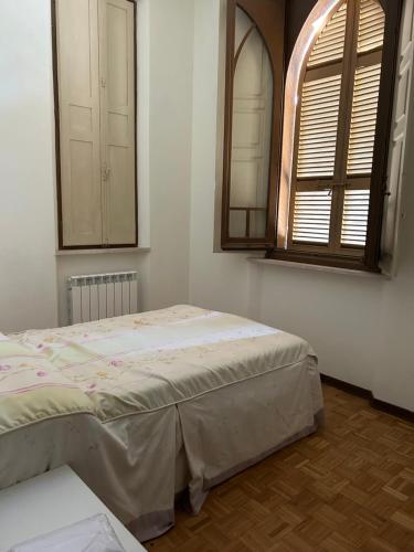 a bedroom with a bed and a mirror and a window at Villa Tirotti in Piacenza