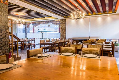 普那卡的住宿－White Dragon Hotel，一间带大桌子和椅子的用餐室
