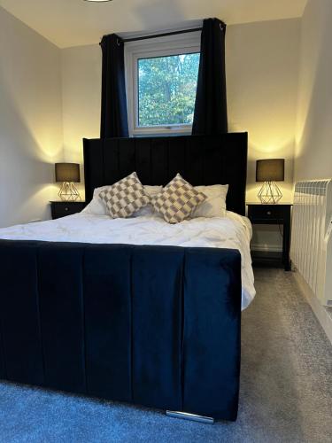 a bedroom with a large blue bed with a window at Entire Apartment boutique king size bed near Town Centre in Colchester