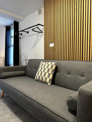 um sofá sentado numa sala de estar ao lado de uma janela em Entire Apartment boutique king size bed near Town Centre em Colchester