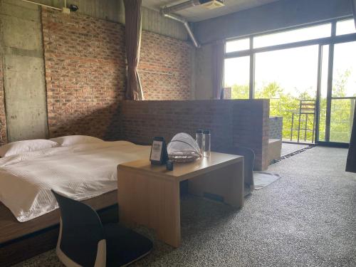 a bedroom with a bed and a desk with a phone at 森活藝術文旅 in Shiding
