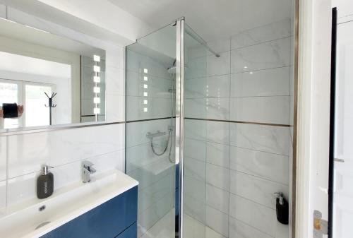 La salle de bains est pourvue d'une douche en verre et d'un lavabo. dans l'établissement F2 "Les Coquelicots", terrasse et piscine privée, à Juvignac