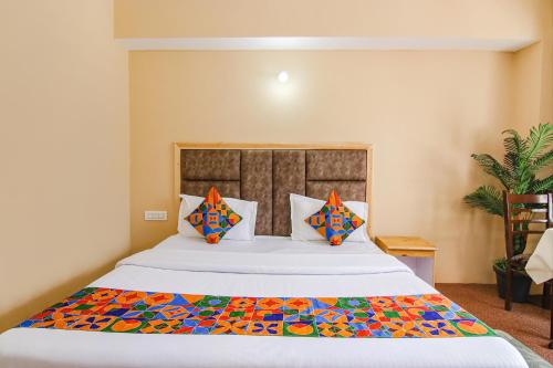 a bedroom with a large bed with a colorful comforter at FabHotel Nirvana Deluxe in Manāli