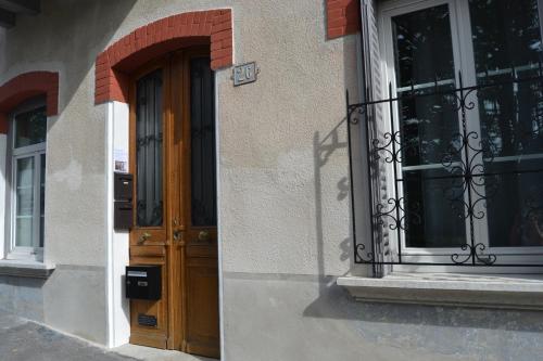 un bâtiment avec une porte en bois et une fenêtre dans l'établissement Studio Hortensia 2 étoiles dans une maison de ville à 400m du centre ville, à Aix-les-Bains