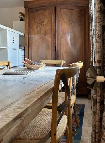 a dining room with a wooden table and chairs at Le cottage de David in Pierrefonds