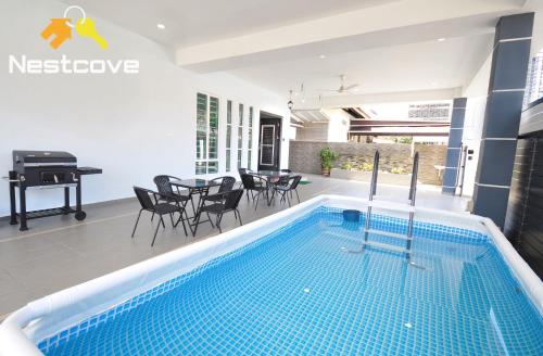 a swimming pool in a house with a piano at Hidden Gem Villa Tengkera Malacca By Nestcove in Melaka