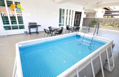a swimming pool in the middle of a house at Tengkera Hidden Gem Villa Malacca City By Nestcove in Melaka